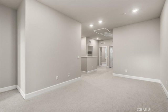 empty room with light carpet, baseboards, and recessed lighting