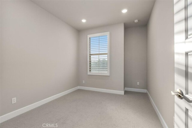 carpeted empty room featuring recessed lighting and baseboards