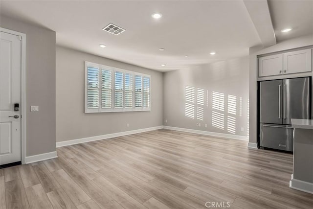 interior space featuring light wood-style floors, visible vents, and recessed lighting