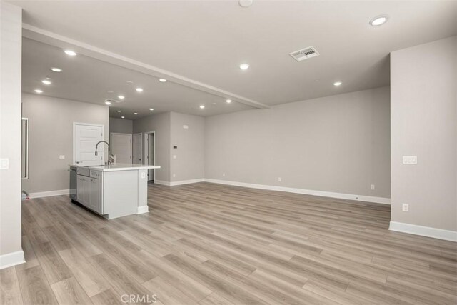 unfurnished living room featuring recessed lighting, visible vents, light wood-style flooring, and baseboards