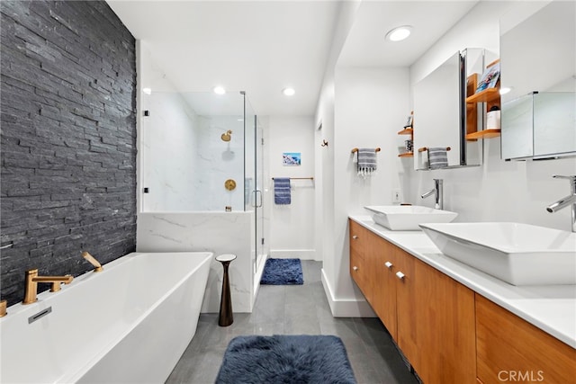 full bathroom featuring a shower stall, a soaking tub, double vanity, and a sink