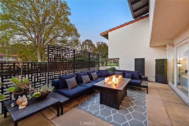 view of patio with an outdoor living space with a fire pit