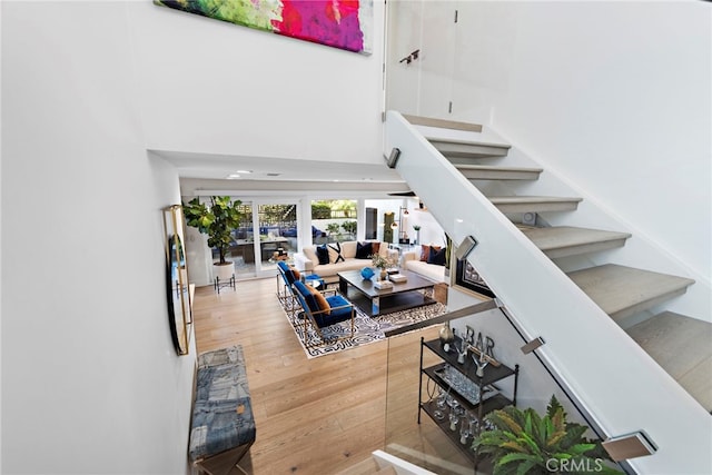 staircase featuring a high ceiling and hardwood / wood-style flooring