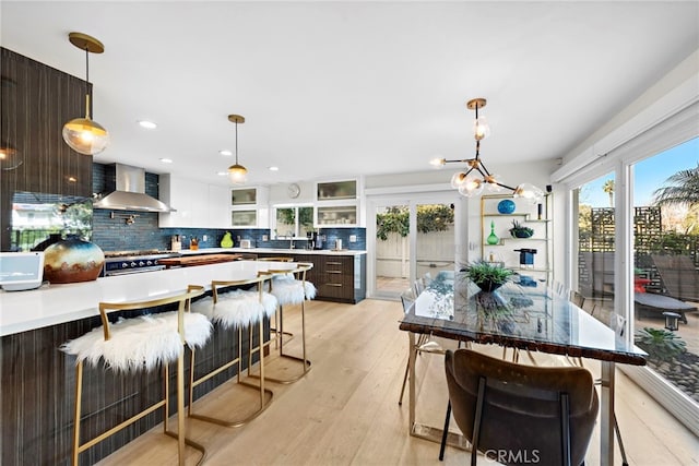 kitchen featuring tasteful backsplash, modern cabinets, and wall chimney exhaust hood