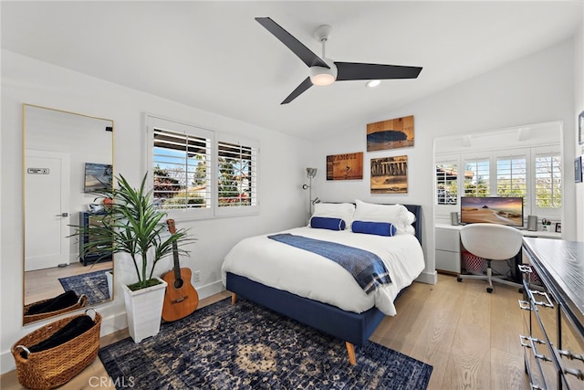 bedroom featuring ceiling fan, baseboards, lofted ceiling, and light wood-style flooring