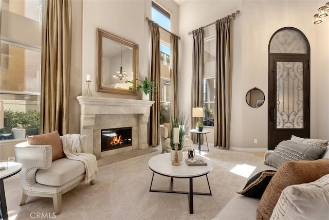 sitting room with a fireplace, baseboards, and carpet flooring