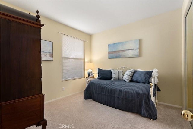 carpeted bedroom with a closet and baseboards