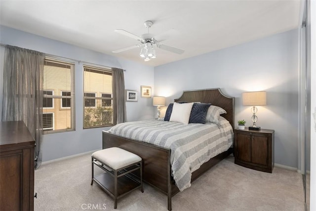 bedroom featuring light colored carpet, ceiling fan, and baseboards