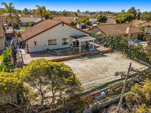 back of house with a pergola, fence, a residential view, and stucco siding