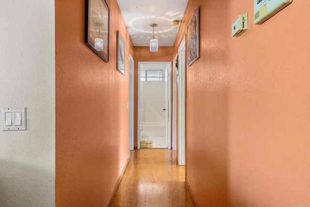 hallway with light wood finished floors and baseboards