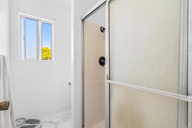 full bathroom featuring marble finish floor, a stall shower, and toilet