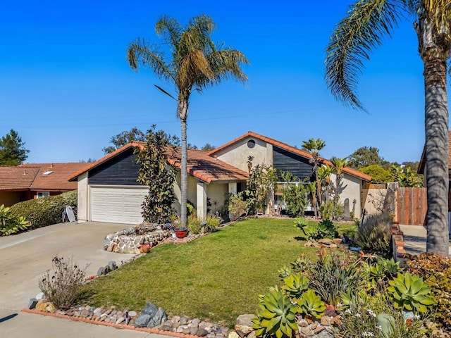 mid-century modern home with stucco siding, a front yard, fence, a garage, and driveway