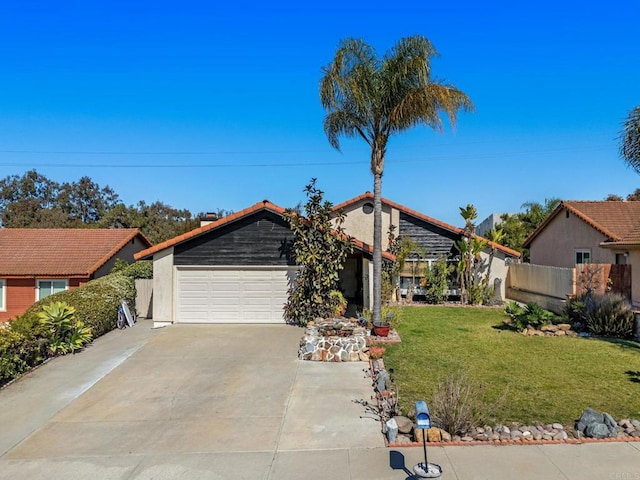 view of front of house featuring driveway, an attached garage, fence, a front yard, and stucco siding