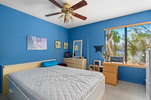 bedroom with a ceiling fan and light colored carpet