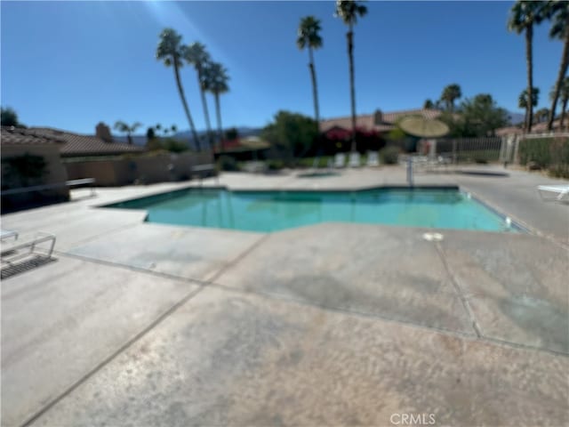 view of swimming pool featuring a patio area, fence, and a fenced in pool