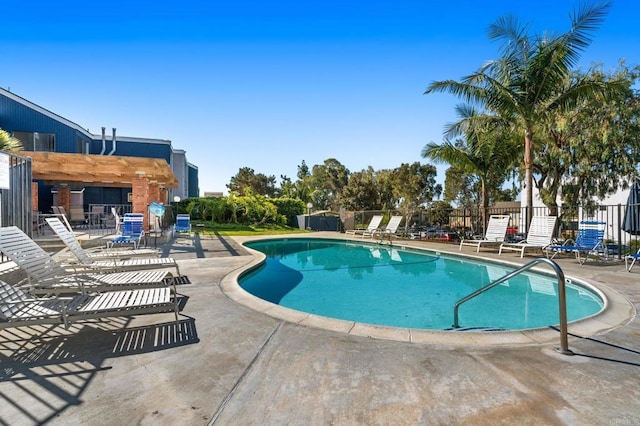 pool with a patio area and fence