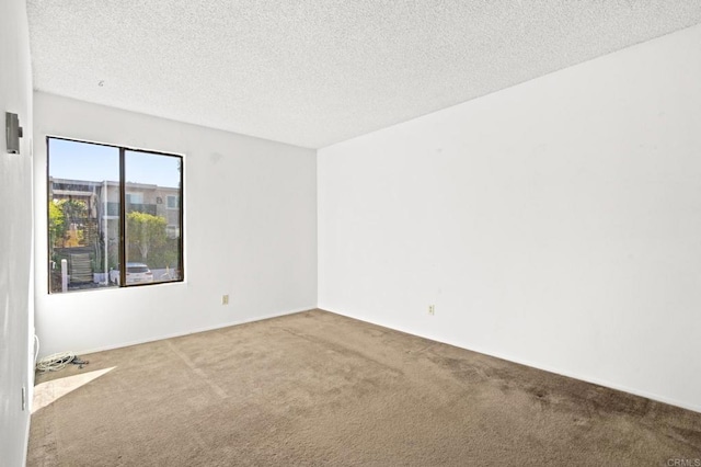 carpeted spare room with a textured ceiling