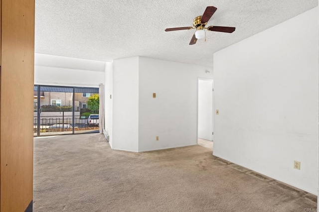 carpeted spare room featuring ceiling fan and a textured ceiling