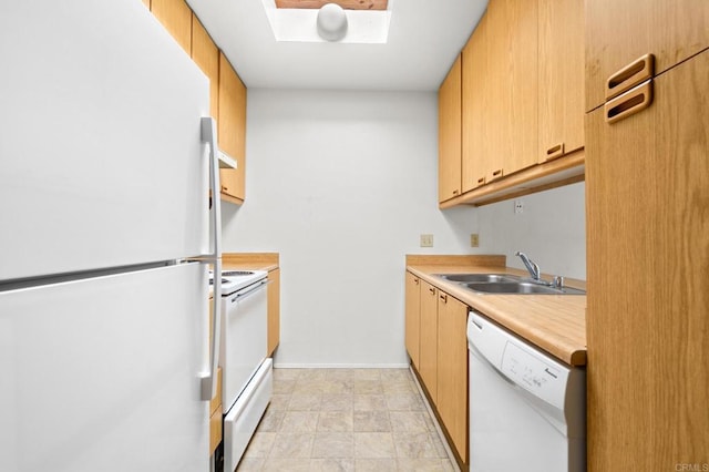 kitchen featuring a skylight, light countertops, a sink, white appliances, and baseboards