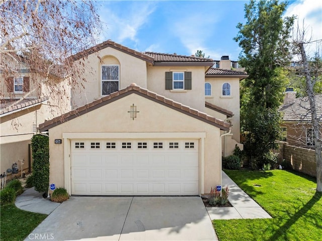 mediterranean / spanish house with driveway, a tiled roof, and stucco siding