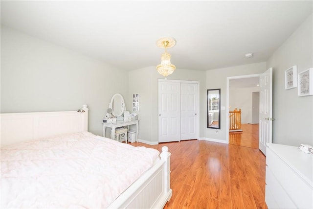 bedroom with a closet, baseboards, and light wood finished floors