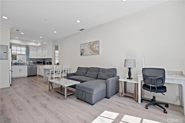 living room featuring ornamental molding, light wood-type flooring, visible vents, and recessed lighting