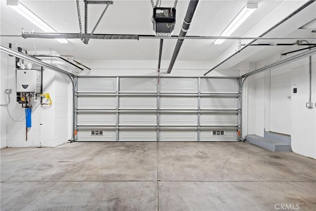 garage featuring tankless water heater and a garage door opener