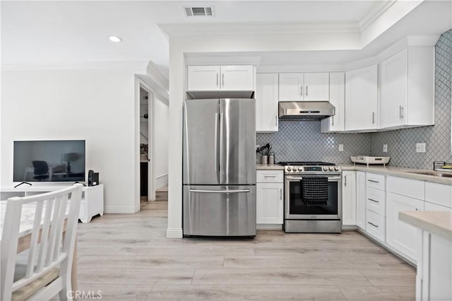 kitchen with ventilation hood, white cabinetry, stainless steel appliances, and light countertops