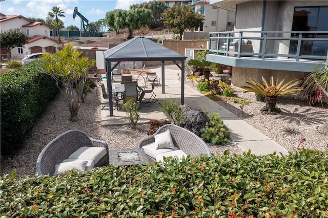 view of community featuring a residential view, fence, a patio, and a gazebo