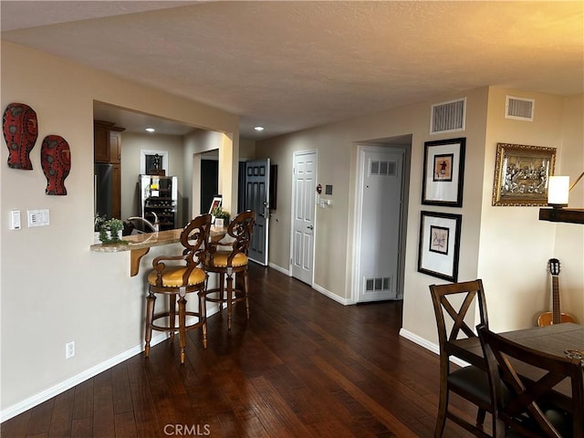 dining room with visible vents and dark wood-style flooring