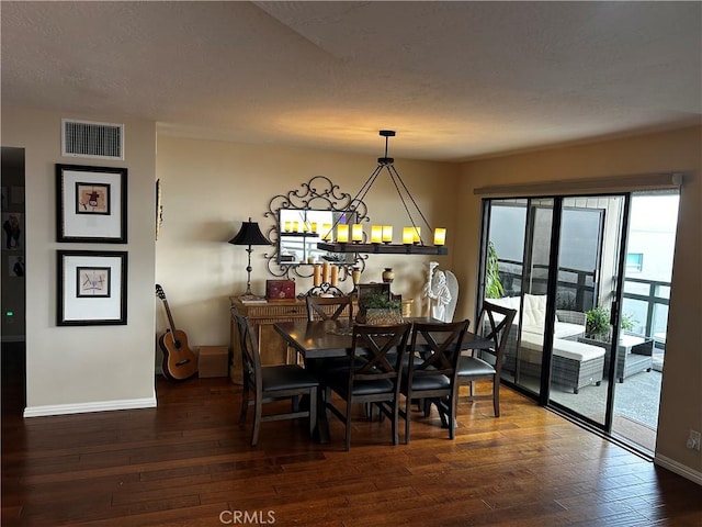 dining room with baseboards, visible vents, and dark wood finished floors