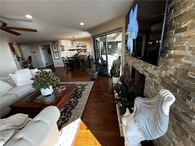 living room featuring dark wood-style flooring, a fireplace, brick wall, and ceiling fan