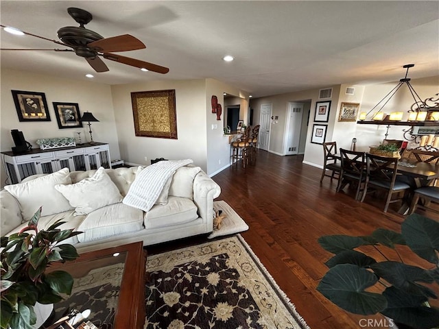 living room featuring ceiling fan, recessed lighting, dark wood-type flooring, visible vents, and baseboards