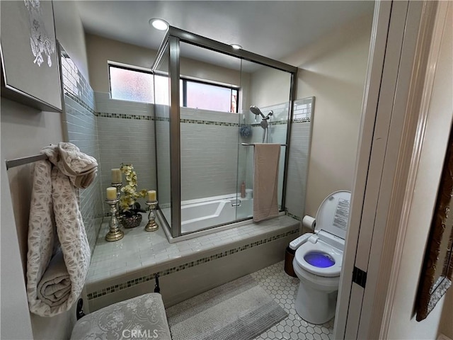 full bath with tile patterned flooring, enclosed tub / shower combo, and toilet