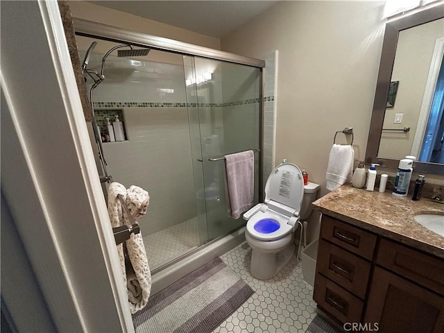 full bath featuring vanity, a shower stall, toilet, and tile patterned floors