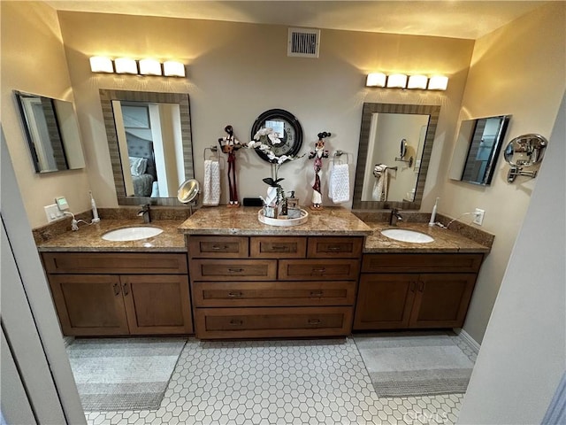 full bath featuring double vanity, visible vents, and a sink