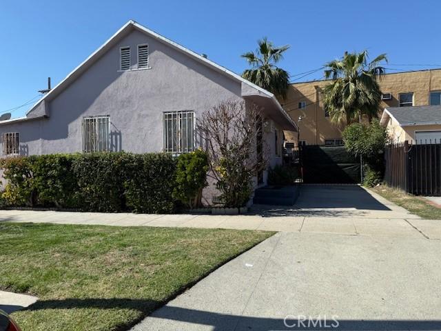 view of property exterior featuring a yard, fence, and stucco siding