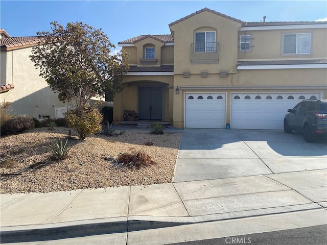 view of front of property with a garage, driveway, a tile roof, and stucco siding