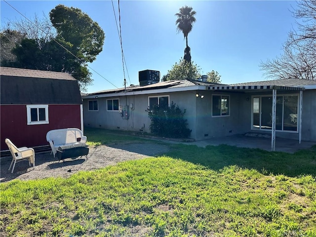 back of property with a yard, central AC, and a patio