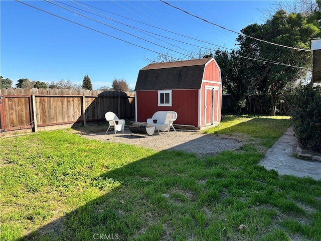 view of shed with a fire pit and a fenced backyard