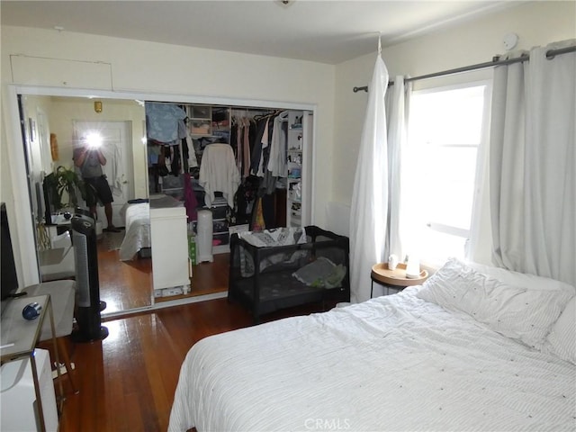 bedroom with dark wood finished floors and a closet