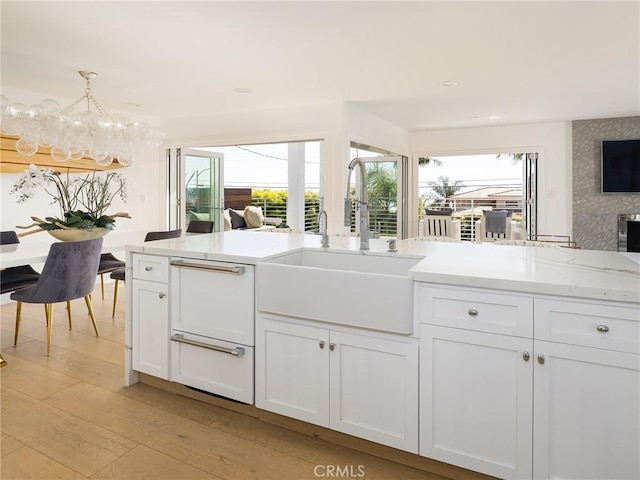 kitchen featuring a sink, a wealth of natural light, and white cabinets