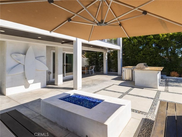 view of patio with a fire pit and area for grilling