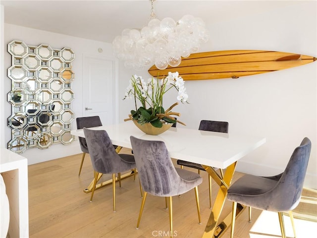 dining space with a notable chandelier and wood finished floors