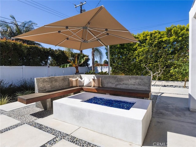 view of patio featuring fence and a fire pit