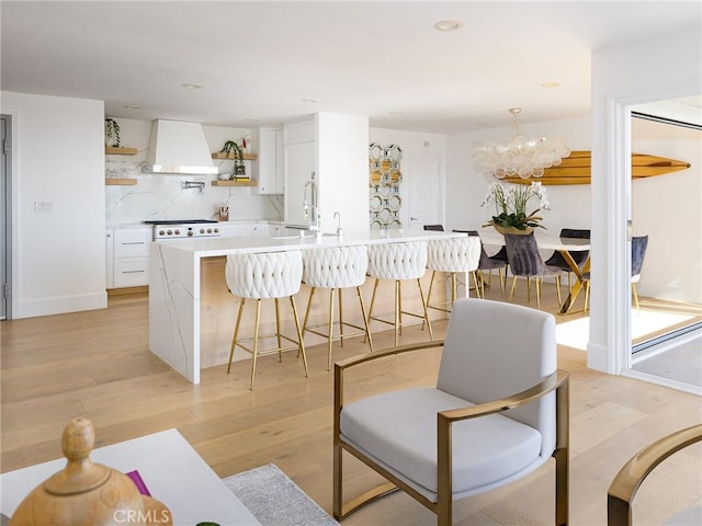 interior space featuring premium range hood, white cabinetry, open shelves, and light countertops