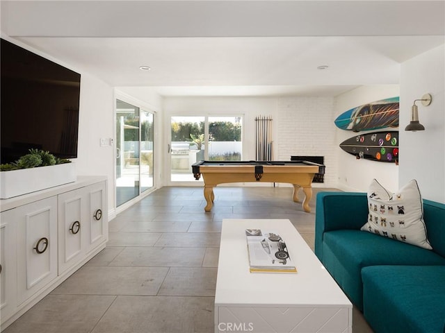 recreation room featuring pool table and a brick fireplace