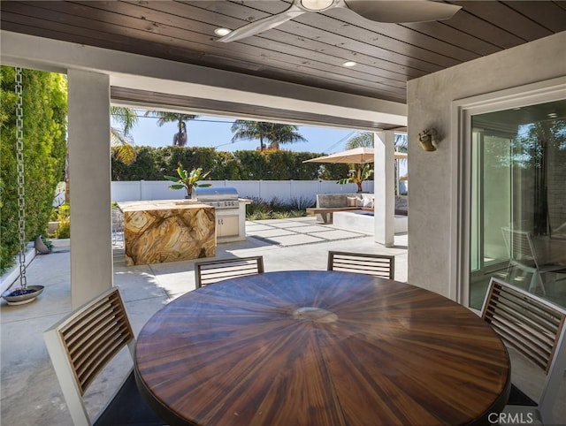 view of patio / terrace with ceiling fan, an outdoor kitchen, fence, and area for grilling