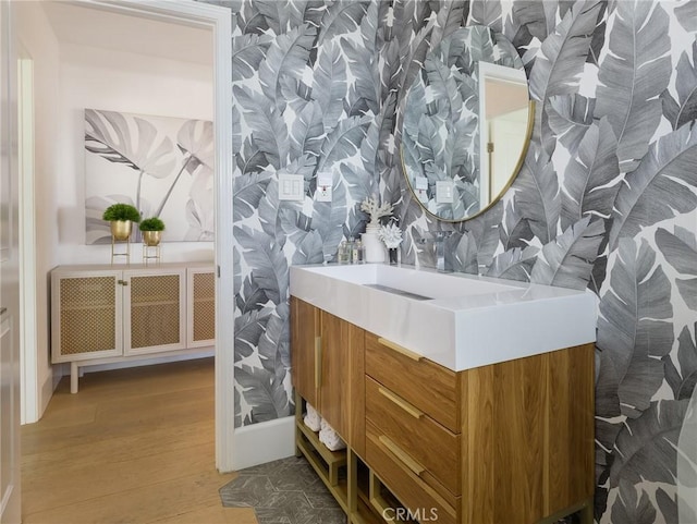 bathroom featuring wallpapered walls, radiator heating unit, wood finished floors, and vanity