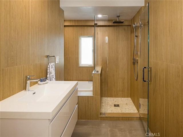 bathroom with a stall shower, a garden tub, vanity, and tile patterned floors